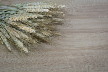 Wheat ears on the wooden table. Sheaf of wheat over wood background. Harvest.