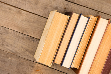 Old and used hardback books or text books on wooden table