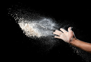 Hand and flour on black background