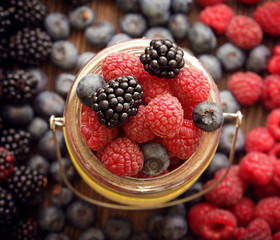 different berries in a basket on a wooden table