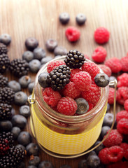 different berries in a basket on a wooden table