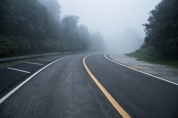 Fototapeta na wymiar The long road through the mist on the mountains.