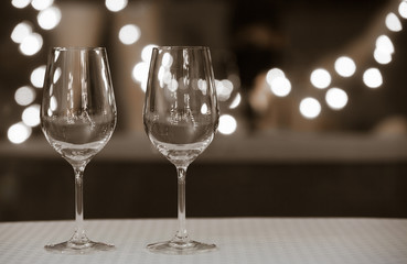 Two empty wine glasses on a bar. 