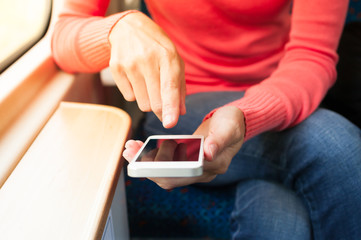 Girl using her smartphone on a train. 
