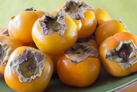 Golden persimmons on a plate