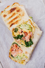 Salmon, Spinach, Cheese and Cucumber Burritos. View from above, top studio shot