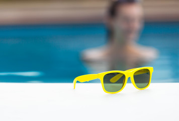 Pair of sunglasses by the pool. 