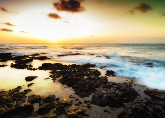 Obraz premium Colorful sunrise on a rocky beach outside Honolulu, Hawaii