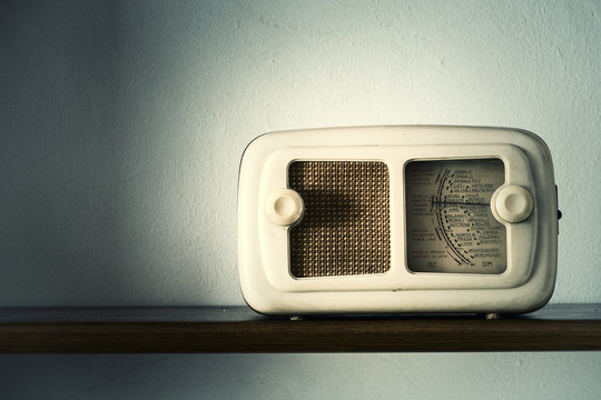 Old retro radio on a wooden shelf with space for text. Vintage photo effect applied.