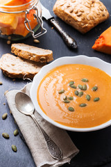 Pumpkin soup in a white bowl on table