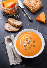 Pumpkin soup in a white bowl on table