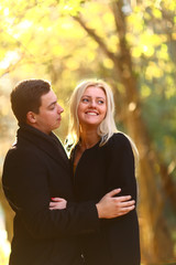 Fototapeta premium Beautiful young couple walking in the autumn park and embracing
