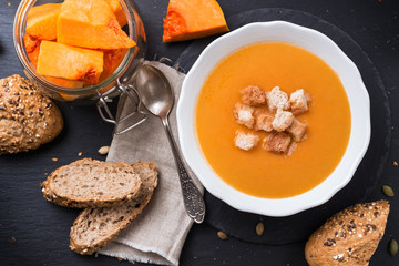 Pumpkin soup in a white bowl on table