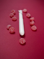 Tampon  with red candies on red background