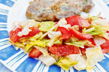 Salad with tomatoes and olive oil and chop.Focus concept.