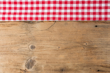 Checkered tablecloth red on the wooden background/ texture