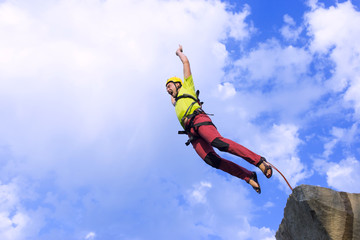 Jump rope from a high rock in the mountains.