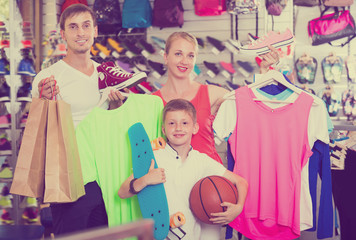 Glad parents with boy in sport store