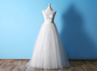 Fototapeta na wymiar Beautiful wedding dress on floor beside wall