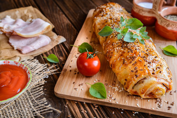 Savory strudel with ham, cheese, tomato sauce and herbs