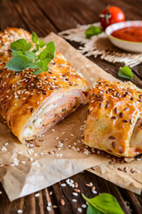 Savory strudel with ham, cheese, tomato sauce and herbs