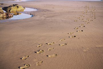 Footprints in the sand on Polzeath beach Vintage Retro Filter.