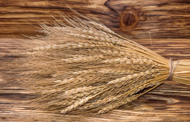 sheaf of ears of wheat on wooden background