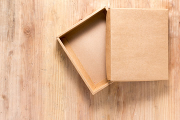 Opened cardboard box on wooden background