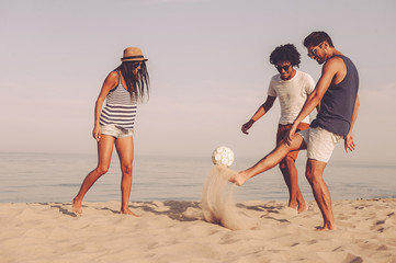 Fototapeta na wymiar Friends playing on beach. 