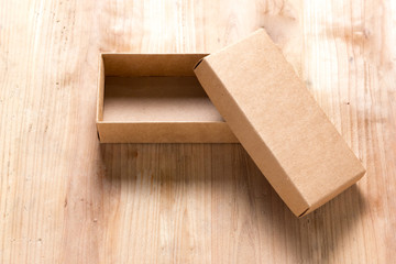 Opened cardboard box on wooden background
