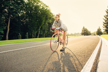 Active young woman on bicycle on the sunset