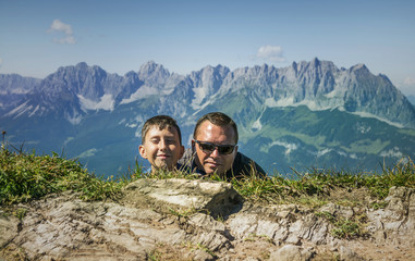 Man and boy hiding .Kitzbuhel peak, Tirol mountains ,Austria.