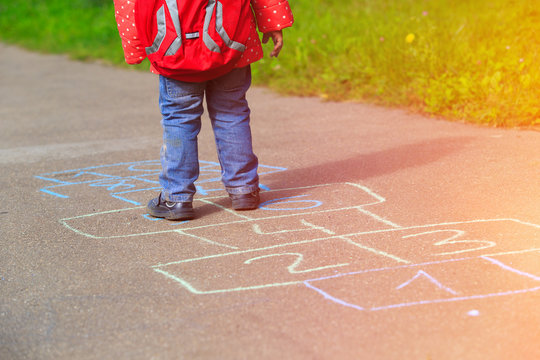 little girl playing hopscotch game after school