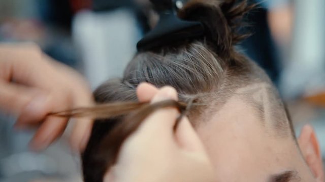 Barber makes braids for young man