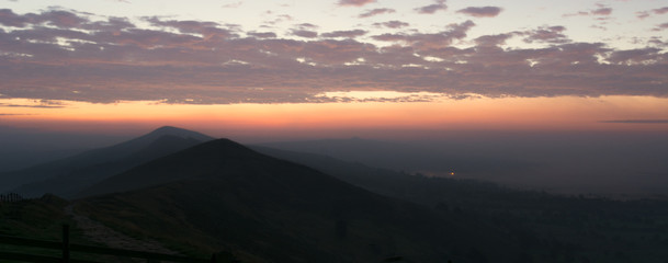 Early dawn sunrise with misty mountain peaks in the English Peak District.