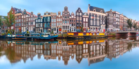 Fotobehang Panorama van het Amsterdamse kanaal Singel met typisch Nederlandse huizen en woonboten tijdens het ochtendblauwe uur, Holland, Nederland. © Kavalenkava