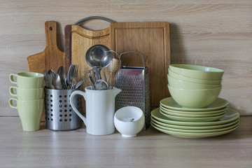 Kitchen still life as background for design. Crockery, tableware and other different stuff on wooden table-top. Image with copy space.