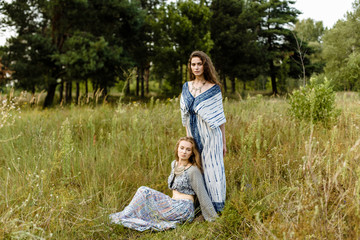 Young girls in ethnic clothes walking in fields. Fashion photo, folklore style