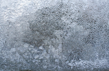 Textured background of bizarre frozen ice on glass