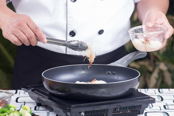 Chef putting shrimp to the pan