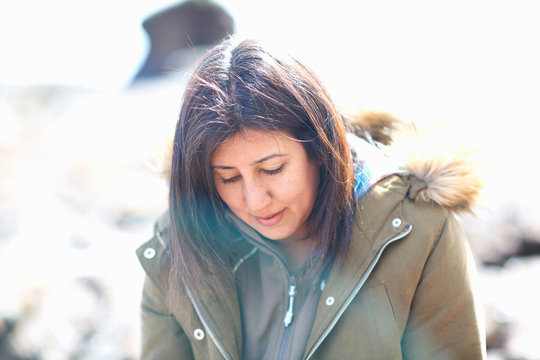 Woman looking down on beach, Devon, UK