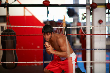 Boxer practising in boxing ring