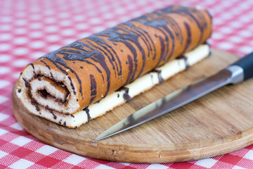Chocolate roll cake on the wooden board
