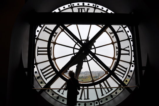 Paris, France: Silhouette of a woman standing in front of the famous clock in the Orsay Museum