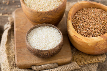 rice, quinoa and buckwheat on wooden surface