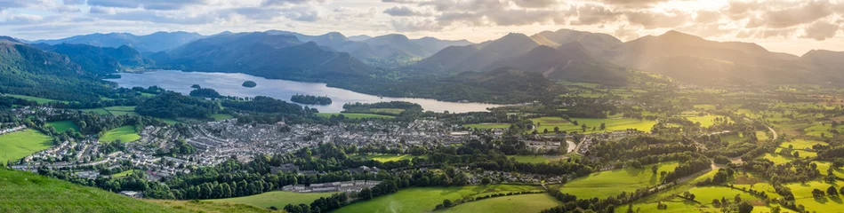 Zelfklevend Fotobehang Panoramic view of Keswick and Derwentwater with beautiful light shining through clouds. © _Danoz