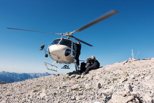 BASE jumping team exiting helicopter on top of mountain, Italian Alps, Alleghe, Belluno, Italy