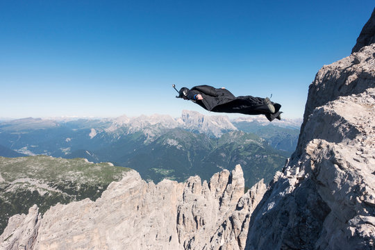 Base jumper flying over mountains