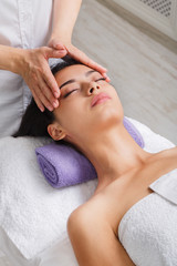 Obraz na płótnie Canvas Woman beautician doctor make head massage in spa wellness center