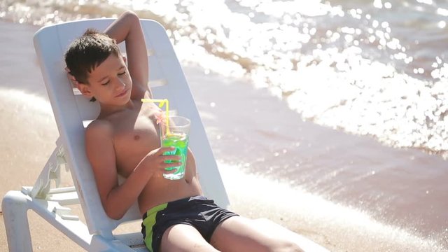 boy drinking cocktail on tropical beach